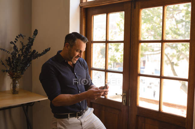 Щасливі чоловічого виконавчий за допомогою мобільного телефону в офісі — стокове фото