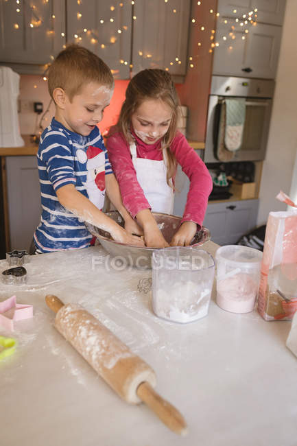 Irmãos preparando massa na cozinha durante o Natal — Fotografia de Stock