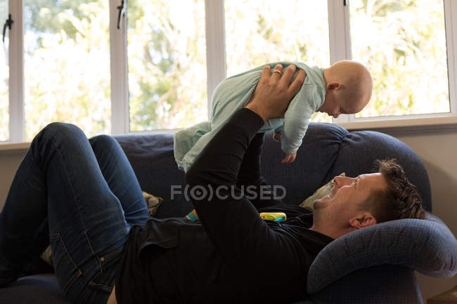 Pai brincando com seu menino na sala de estar em casa — Fotografia de Stock
