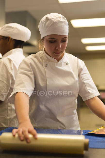 Жінка-кухарка тримає пластикову обгортку на кухні — стокове фото