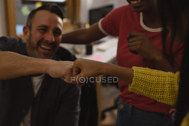 Щасливі бізнес-колеги дають кулакові удари — стокове фото