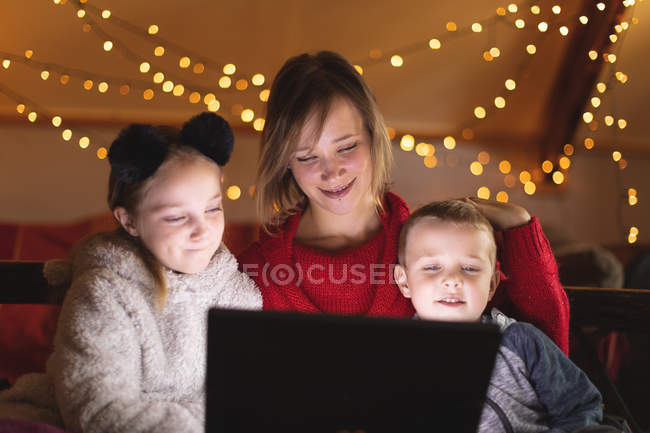 Mãe sorridente e crianças usando tablet digital em casa — Fotografia de Stock