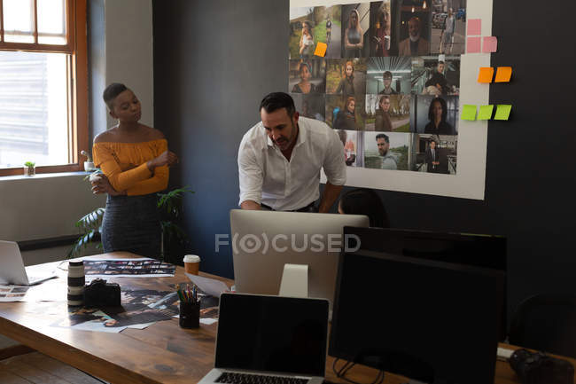 Geschäftskollegen diskutieren am Schreibtisch im Büro am Computer — Stockfoto