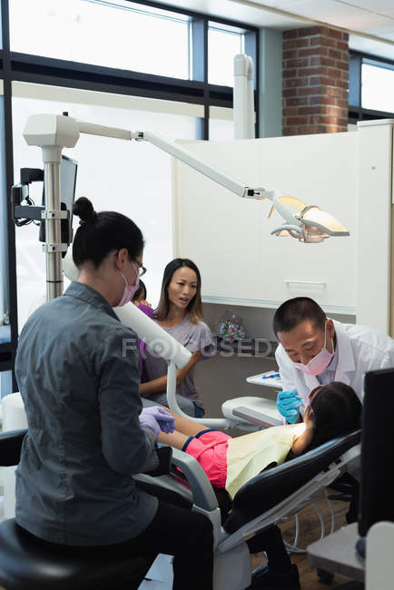 Чоловічий стоматолог оглядає пацієнта за допомогою інструментів у клініці — стокове фото