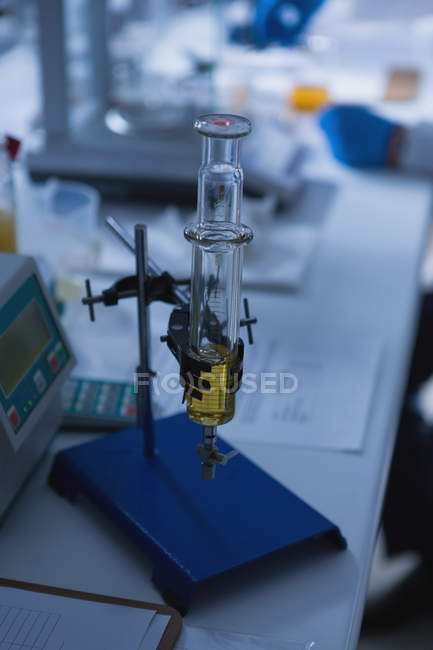 Primo piano della siringa di vetro con supporto disposto sul tavolo in laboratorio — Foto stock