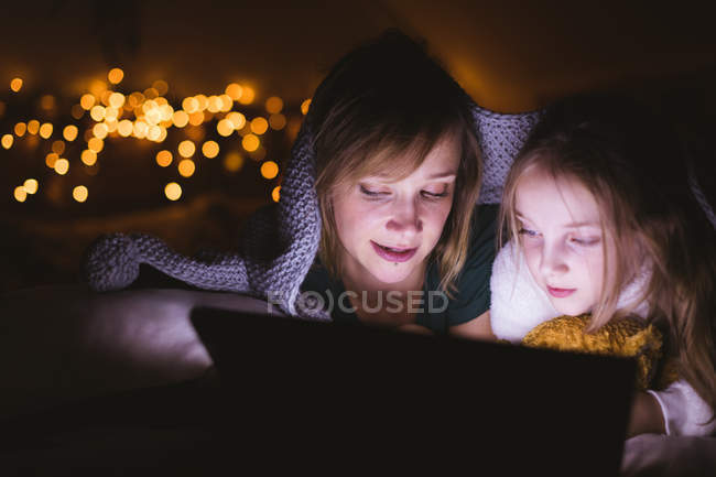 Закри матері і дочки, використовуючи цифровий планшетний проти Різдвяні вогні — стокове фото