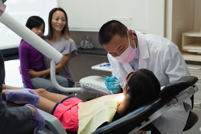 Zahnarzt untersucht Patientin mit Werkzeug in Klinik — Stockfoto