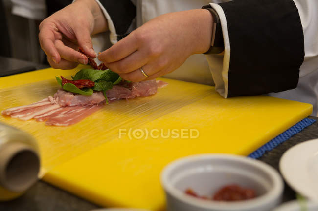 Крупним планом шеф-кухар прикрашає м'ясо м'ясом на кухні — стокове фото