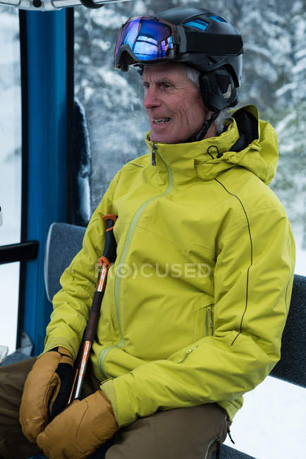 Homme âgé souriant voyageant dans un téléski — Photo de stock