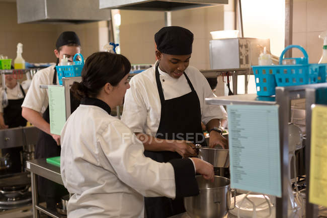 Two female chef preparing food in kitchen at restaurant — Stock Photo
