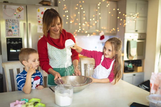 Lächelnde Mutter und Kinder backen Weihnachtsplätzchen zu Hause — Stockfoto