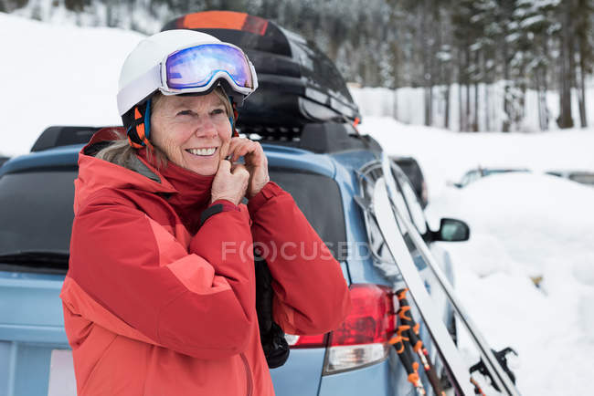 Smiling senior woman wearing ski helmet — Stock Photo