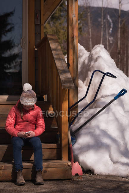 Girl using mobile phone during winter on a sunny day — Stock Photo