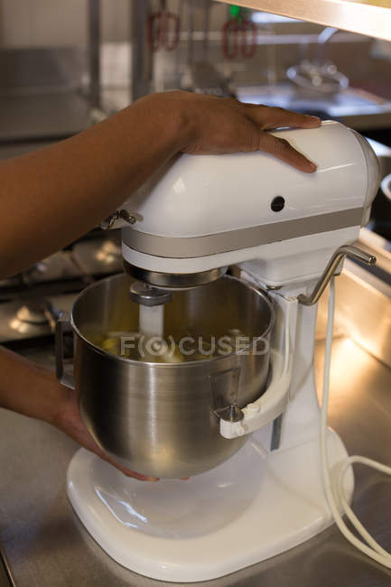 Mid section of chef using kneading machine in kitchen — Stock Photo