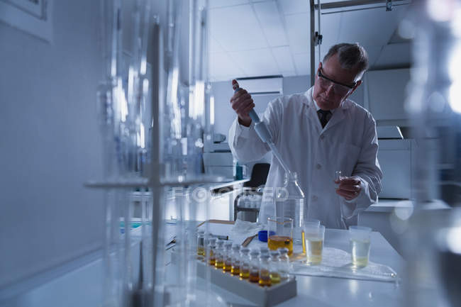 Scientifique masculin attentif expérimentant en laboratoire — Photo de stock