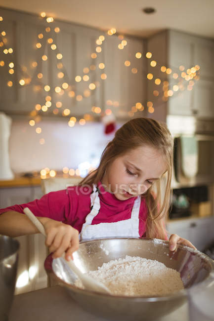 Девочка готовит тесто для рождественского печенья дома — стоковое фото