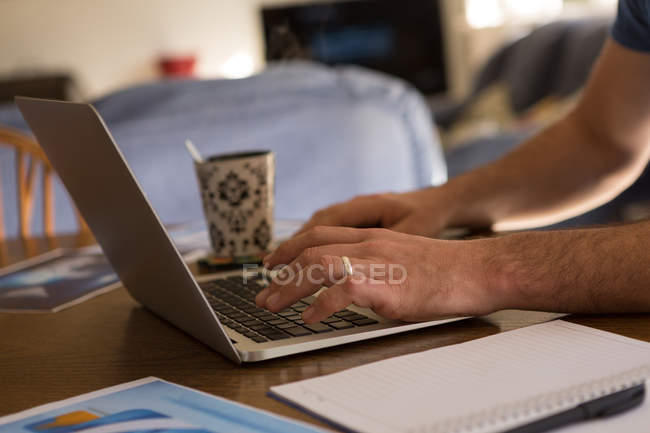 Крупним планом чоловік використовує ноутбук вдома — стокове фото