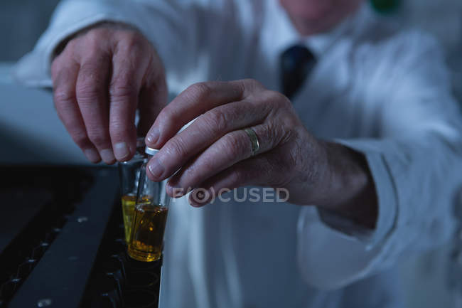 Männlicher Wissenschaftler platziert medizinische Ampullen auf einer Labormaschine im Labor — Stockfoto