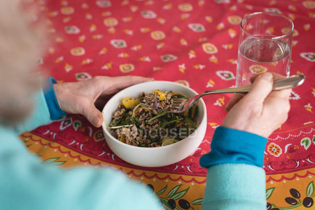 Nahaufnahme einer Seniorin beim Essen zu Hause — Stockfoto