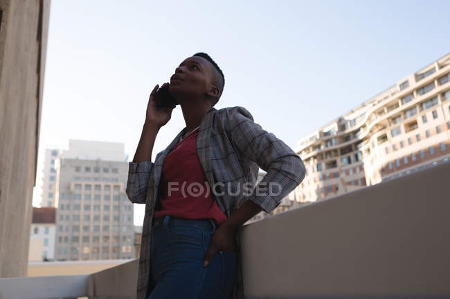 Бізнес-леді бере на мобільний телефон на балконі офісу — стокове фото