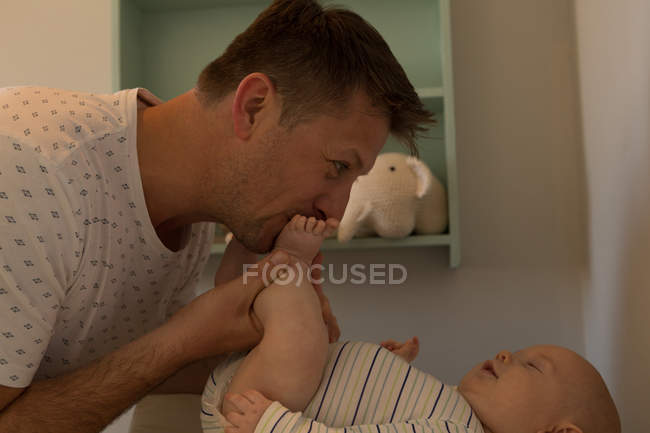 Happy father playing with his baby boy at home — Stock Photo