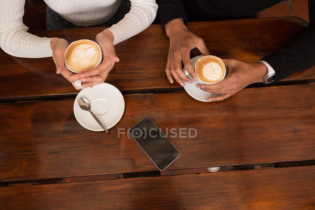 Overhead di coppia che prende il caffè in caffè — Foto stock