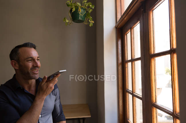 Feliz hombre ejecutivo hablando en el teléfono móvil en la oficina - foto de stock