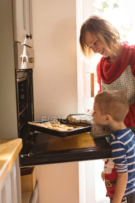 Curioso madre e figlio guardando i biscotti al forno — Foto stock