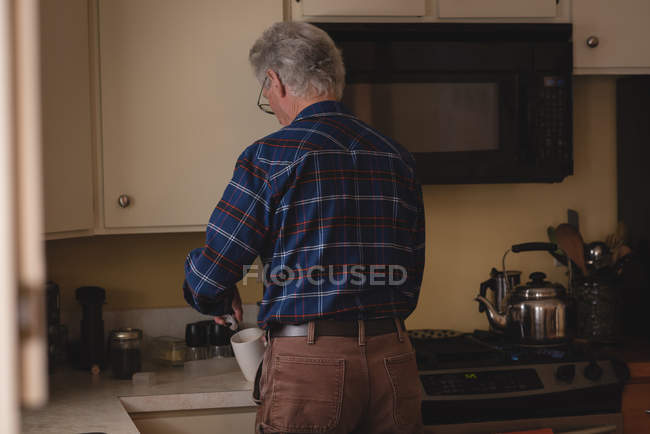 Senior man preparing coffee in kitchen at home — Stock Photo