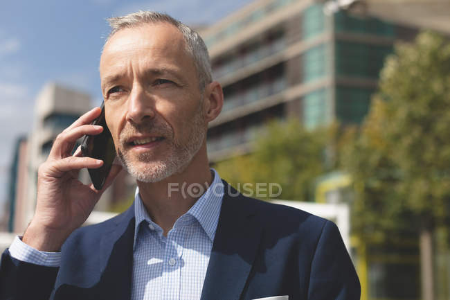 Primo piano dell'uomo d'affari che parla al cellulare in città — Foto stock