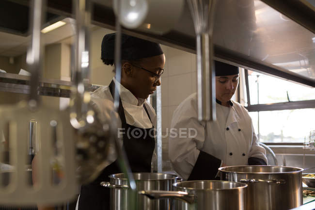 Chefs féminins travaillant en cuisine au restaurant — Photo de stock