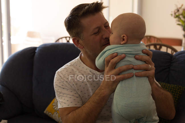 Père jouant avec son petit garçon dans le salon à la maison — Photo de stock