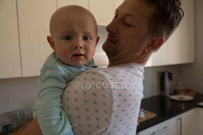 Pai segurando seu menino na cozinha em casa — Fotografia de Stock