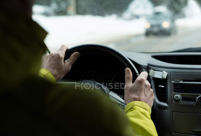 Вид ззаду літнього чоловіка, що водить машину на вулиці — стокове фото