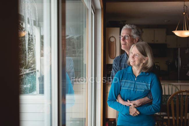 Sorridente coppia di anziani che si abbracciano a casa — Foto stock