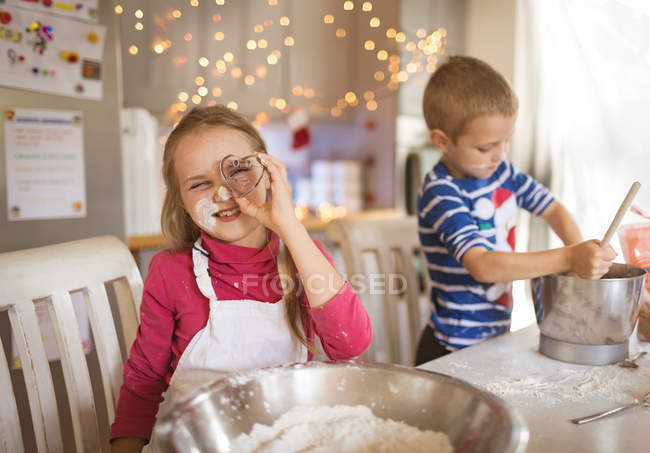 Menina sorridente mostrando um cortador de biscoitos em forma de coração — Fotografia de Stock