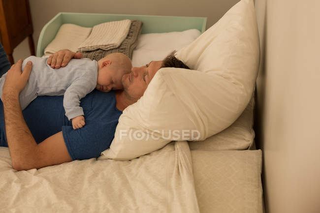 Pai e menino da baía dormindo no quarto em casa — Fotografia de Stock