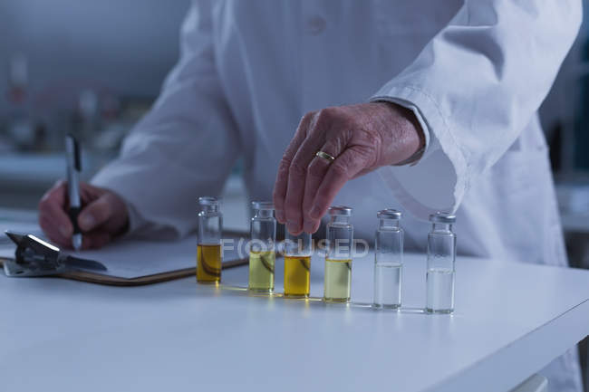 Mid section of male scientist experimenting in laboratory — Stock Photo