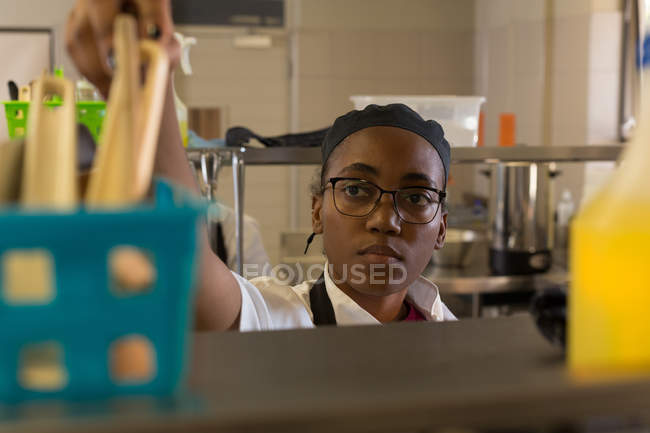 Female chef working in kitchen at restaurant — Stock Photo