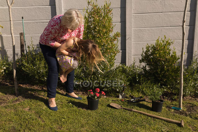 Avó e neta brincando no jardim em um dia ensolarado — Fotografia de Stock