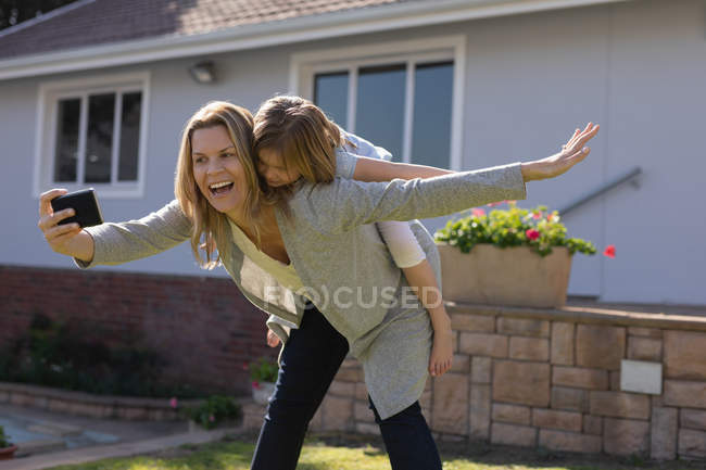 Mutter und Tochter machen Selfie mit Handy im Garten — Stockfoto