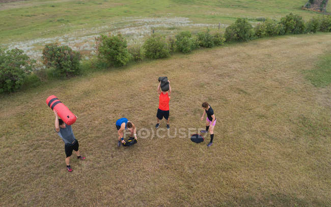 Visão de alto ângulo do grupo de pessoas que se exercitam no campo — Fotografia de Stock