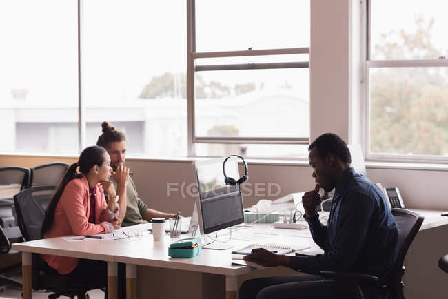 Три бізнесмени працюють в офісі — стокове фото