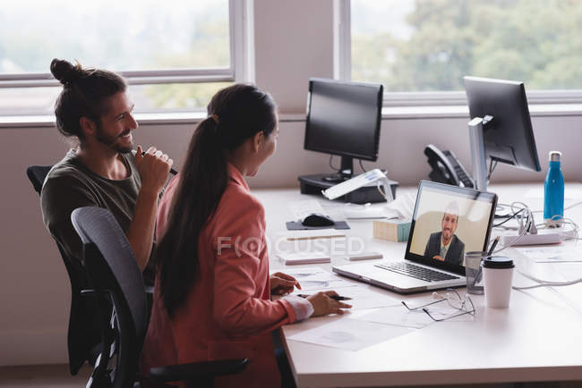 Homme d'affaires et femme d'affaires ayant une réunion de vidéoconférence dans le bureau — Photo de stock