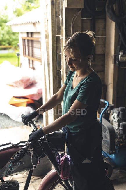 Feminino mecânico reparação de moto na garagem — Fotografia de Stock