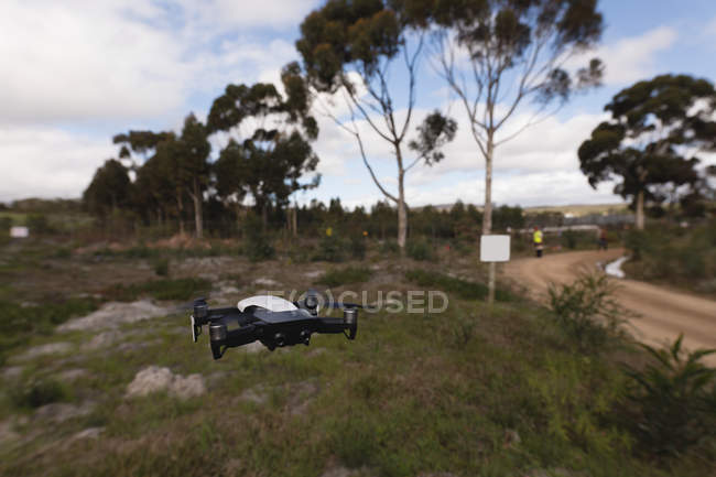 Drone hovering in the air at forest — Stock Photo