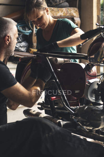 Close-up de mecânica de reparação de moto na garagem — Fotografia de Stock