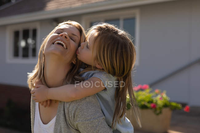 Mère heureuse donnant le tour de piggyback à sa fille dans le porche — Photo de stock