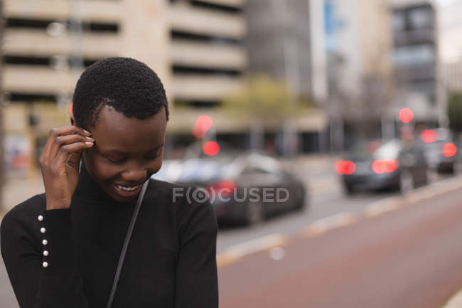 Щаслива жінка стоїть на міській вулиці — стокове фото