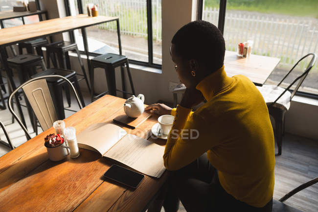 Вид збоку жінки, дивлячись меню в кафе — стокове фото